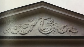 widoczny płaskorzeźbiony ornament z monogramem AC (Amelia Christiani) oraz dekoracyjne wici roślinne