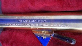 tuba, w której mieści się akt erekcyjny, lokalne gazety z 16.02 oraz monety, które są obecnie w obie