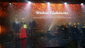 Rozświetlona scena widowiska, po prawej stronie muzycy klasyczni wraz z instrumentami, po prawej w s