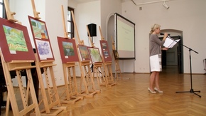 Dyrektor Muzeum odczytuje wyniki, na pierwszym planie nagrodzone prace