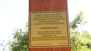 pamiątkowa tabliczka przymocowana na krzyżu