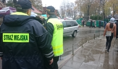 Zdjęcie strażnika miejskiego pracującego w dniu Wszystkich Świętych (link otworzy duże zdjęcie)